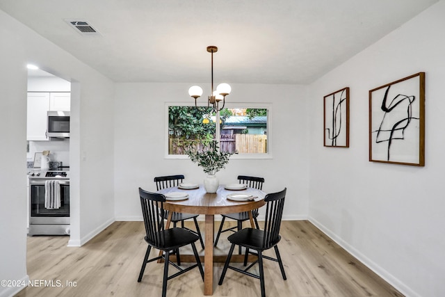 dining room featuring light hardwood / wood-style flooring and an inviting chandelier