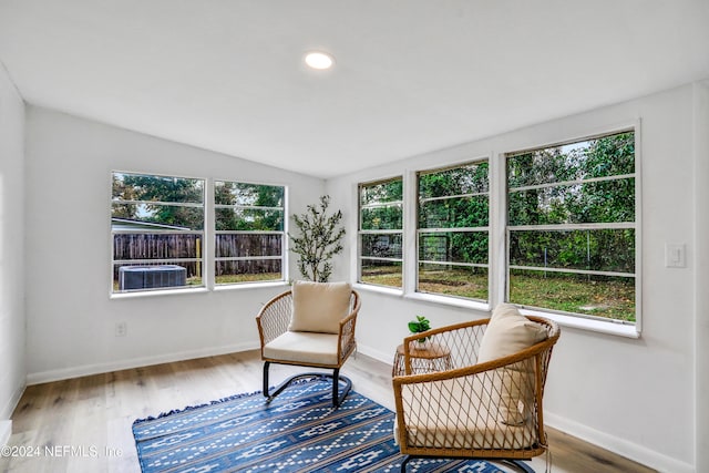 sitting room with hardwood / wood-style floors and vaulted ceiling