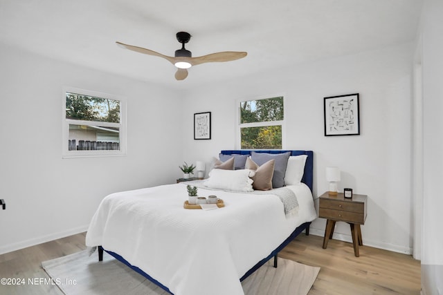 bedroom featuring light hardwood / wood-style flooring, multiple windows, and ceiling fan