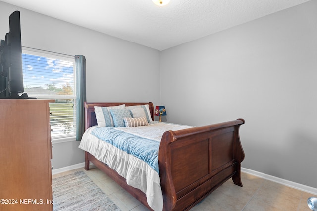 bedroom with light tile patterned floors and a textured ceiling