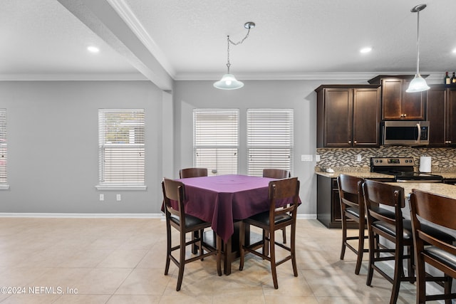 tiled dining room with a textured ceiling and ornamental molding