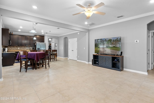 living room featuring ceiling fan, crown molding, and light tile patterned flooring