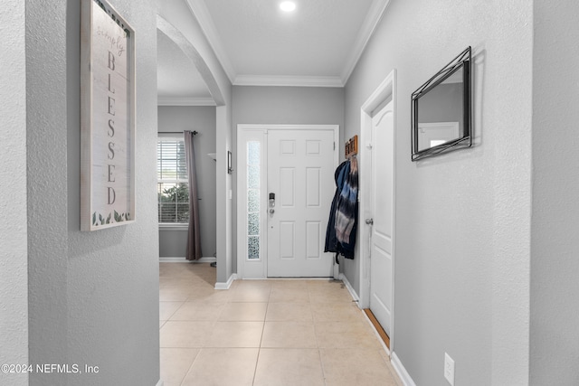 foyer with ornamental molding, a textured ceiling, and light tile patterned floors