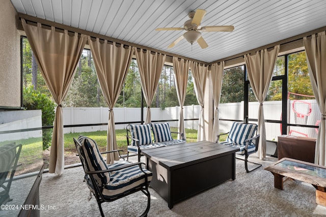 sunroom / solarium featuring a wealth of natural light, wooden ceiling, and ceiling fan