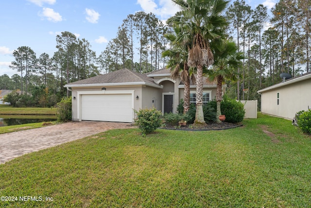 view of front of home featuring a garage, a water view, and a front lawn