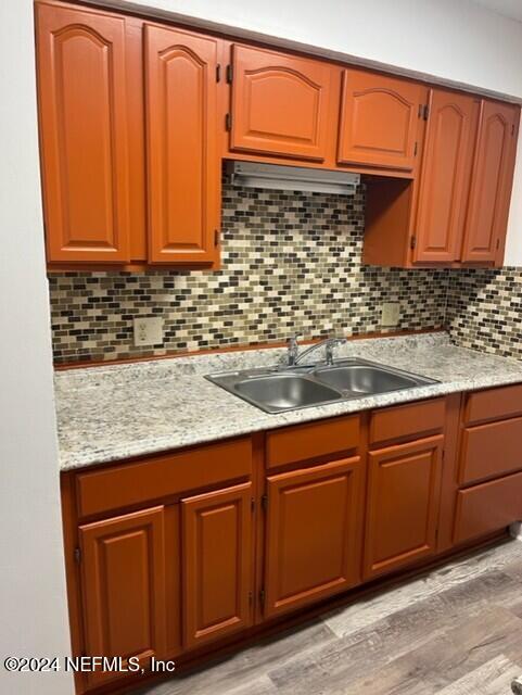 kitchen featuring decorative backsplash, light hardwood / wood-style flooring, and sink