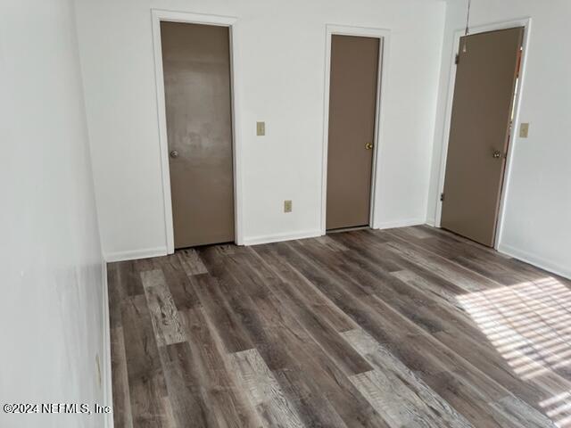 unfurnished bedroom with dark wood-type flooring