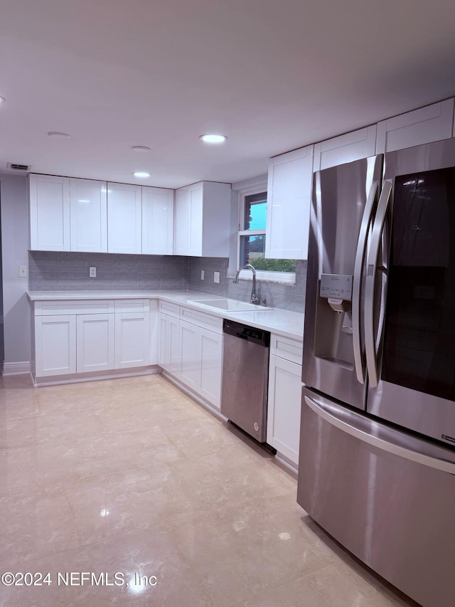 kitchen featuring white cabinets, sink, and appliances with stainless steel finishes