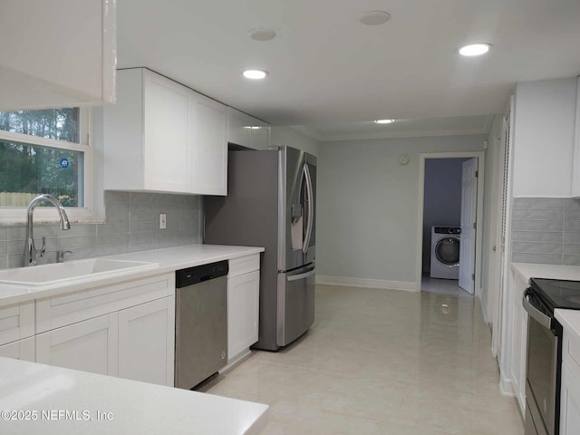 kitchen with white cabinets, stainless steel appliances, washer / clothes dryer, and sink