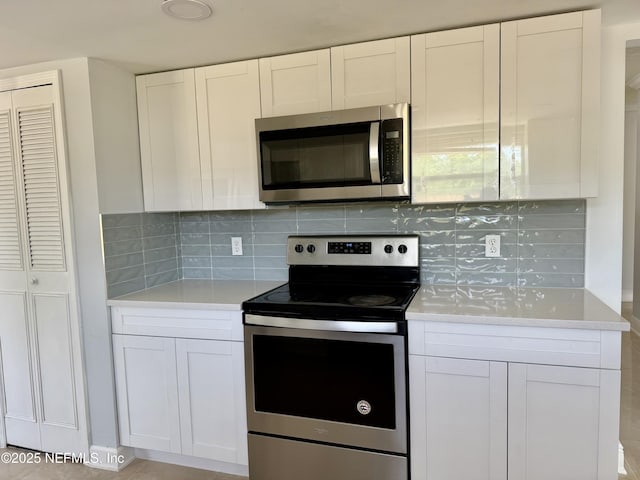 11050 Oak Ridge Dr N, Jacksonville, FL 32225 - kitchen with white cabinetry, light countertops, tasteful backsplash, and appliances with stainless steel finishes