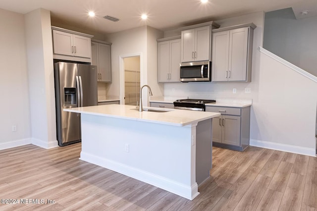 kitchen featuring gray cabinets, sink, light hardwood / wood-style floors, and appliances with stainless steel finishes