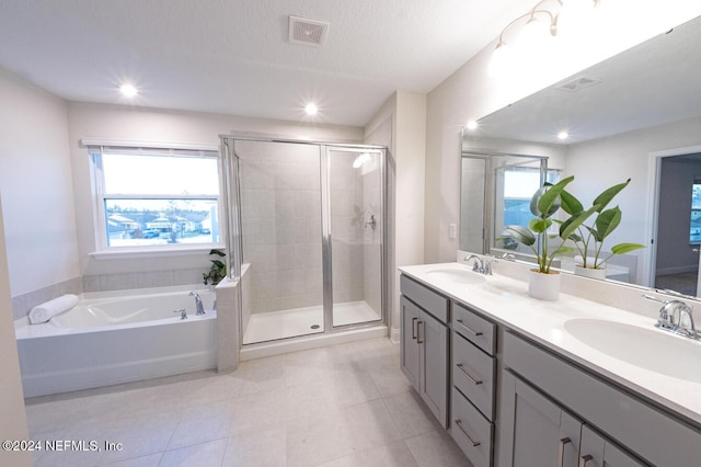 bathroom featuring plus walk in shower, vanity, and a healthy amount of sunlight