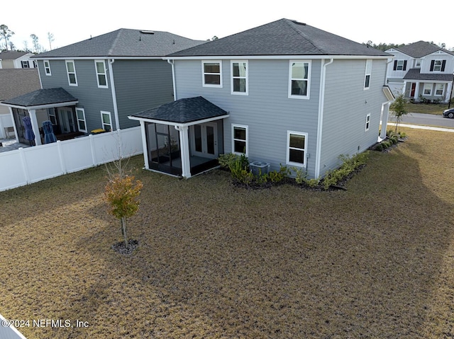 back of house with a lawn, a sunroom, and central AC unit