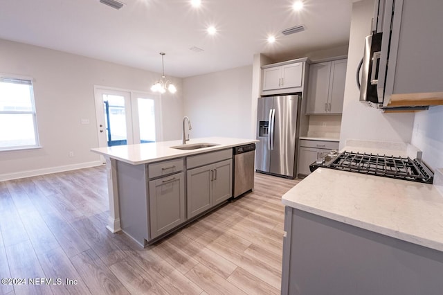 kitchen featuring stainless steel appliances, sink, a center island with sink, light hardwood / wood-style flooring, and gray cabinets