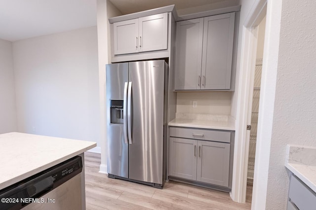 kitchen featuring gray cabinetry, light hardwood / wood-style flooring, and stainless steel appliances