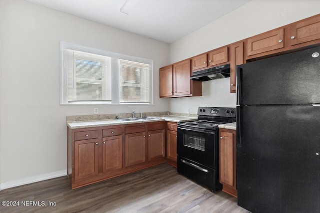 kitchen featuring black appliances, sink, and hardwood / wood-style floors