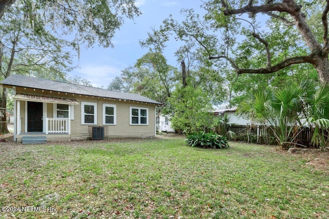 back of house featuring central AC and a yard