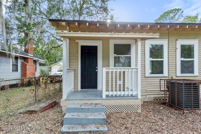 doorway to property with central AC and a porch