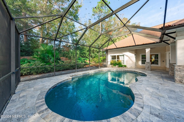 view of swimming pool with a lanai and a patio area