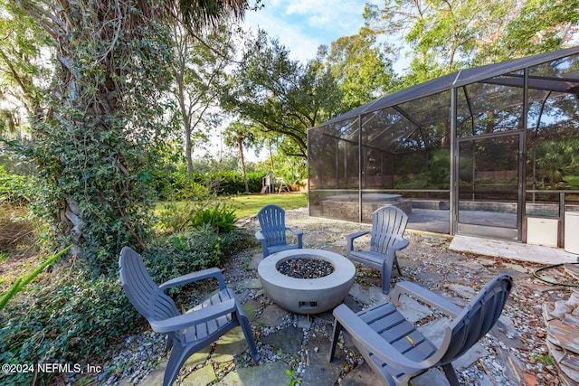 view of patio featuring a fire pit and a lanai