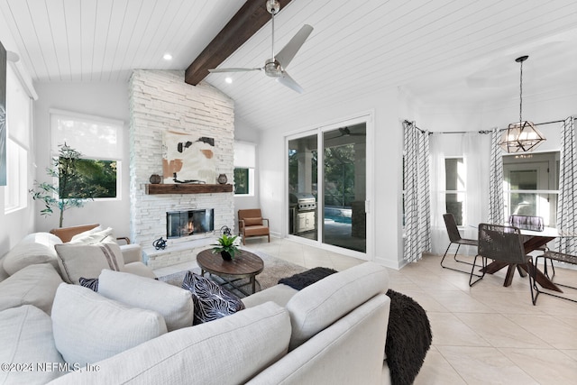 tiled living room with wood ceiling, a stone fireplace, lofted ceiling with beams, and ceiling fan with notable chandelier