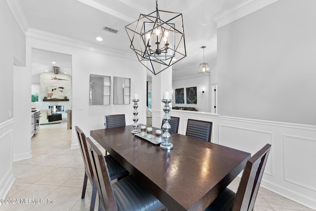 tiled dining space with ornamental molding and a chandelier