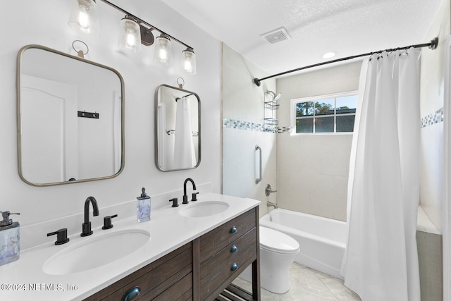 full bathroom featuring tile patterned floors, a textured ceiling, toilet, shower / bath combo with shower curtain, and vanity