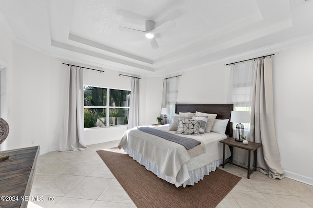 bedroom featuring ceiling fan, a raised ceiling, light tile patterned floors, and crown molding