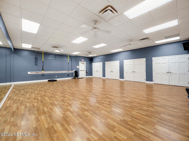 exercise area featuring a drop ceiling and wood-type flooring