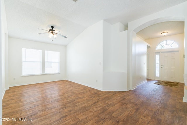 entryway featuring a textured ceiling, dark hardwood / wood-style flooring, ceiling fan, and lofted ceiling