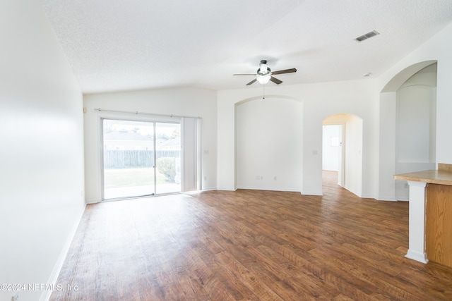 unfurnished living room featuring ceiling fan, dark hardwood / wood-style flooring, a textured ceiling, and vaulted ceiling