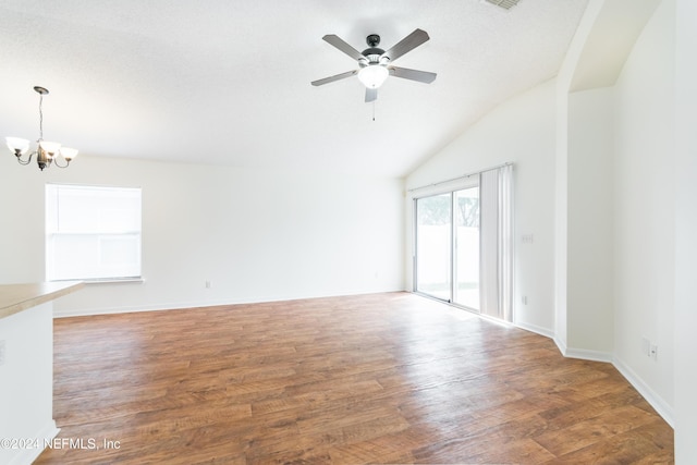 unfurnished living room featuring a textured ceiling, dark hardwood / wood-style floors, lofted ceiling, and ceiling fan with notable chandelier