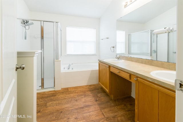 bathroom featuring hardwood / wood-style floors, vanity, independent shower and bath, and vaulted ceiling