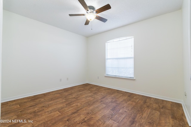 spare room with dark hardwood / wood-style floors and ceiling fan