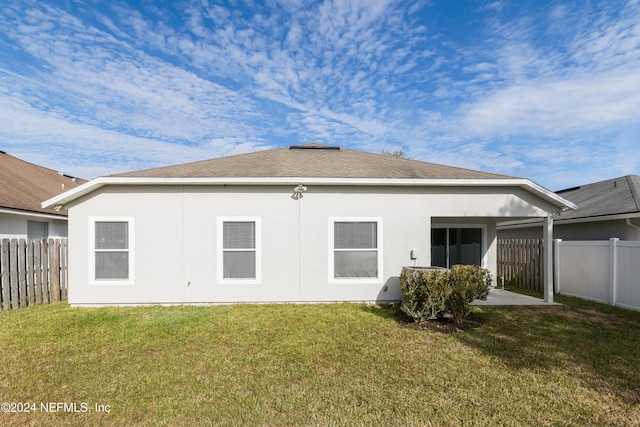 rear view of house featuring a lawn