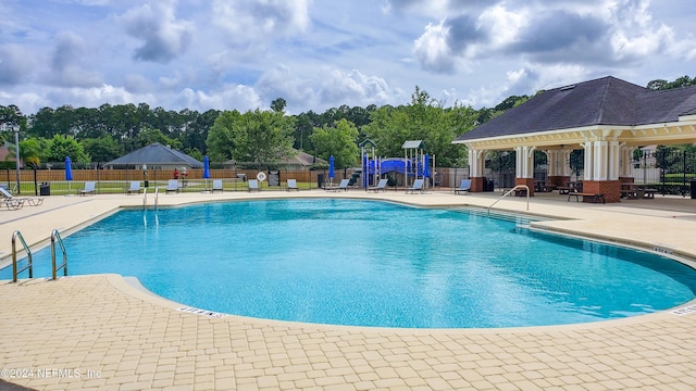 view of pool featuring a playground and a patio