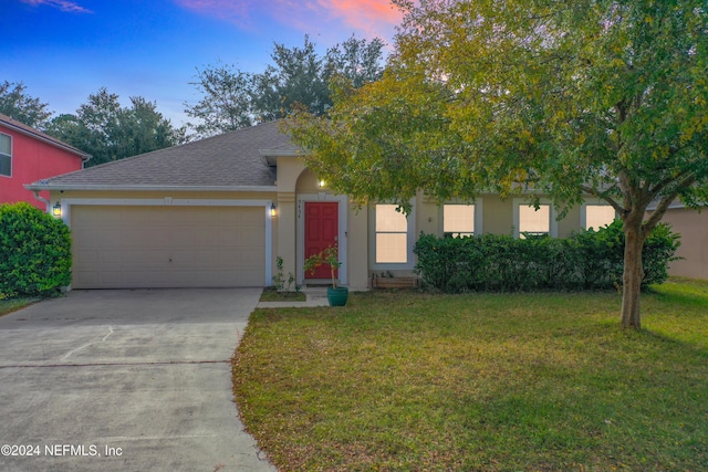 obstructed view of property featuring a garage and a lawn