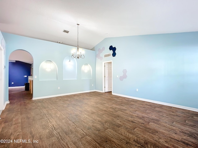 empty room featuring dark hardwood / wood-style flooring, lofted ceiling, and an inviting chandelier