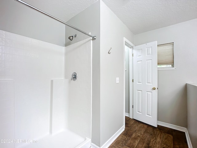 bathroom featuring a shower, hardwood / wood-style floors, and a textured ceiling