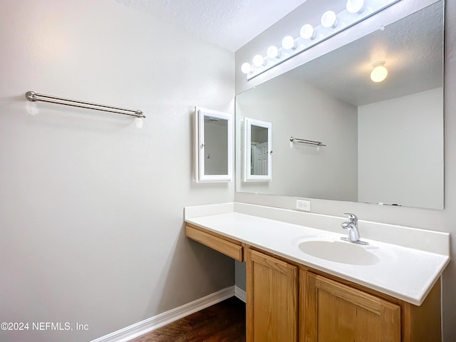 bathroom featuring hardwood / wood-style floors, vanity, and a textured ceiling