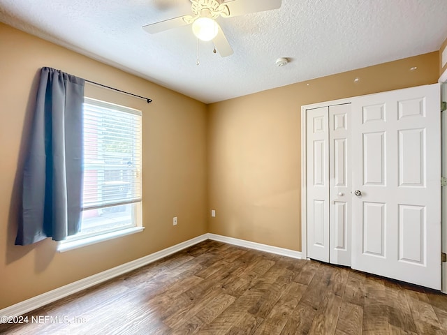 unfurnished bedroom featuring hardwood / wood-style floors, a textured ceiling, a closet, and ceiling fan