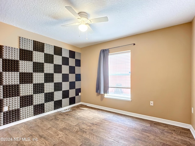 empty room with a textured ceiling, hardwood / wood-style flooring, and ceiling fan