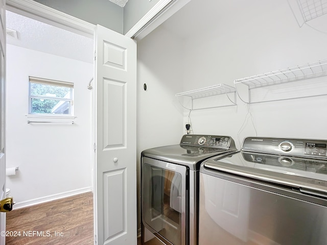 clothes washing area featuring independent washer and dryer and dark wood-type flooring