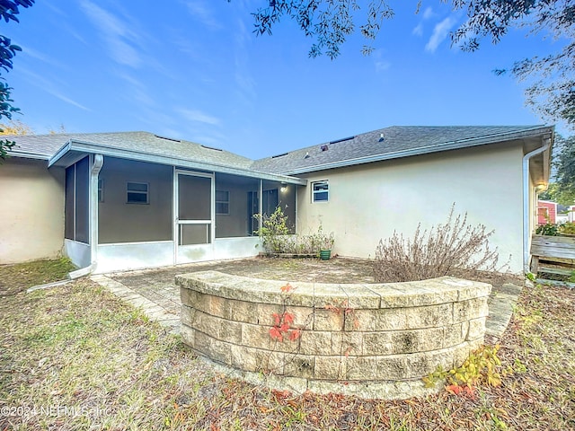 rear view of property with a sunroom and a patio