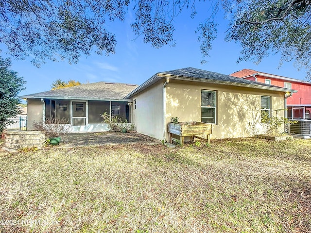 back of property featuring a yard, central AC, and a sunroom