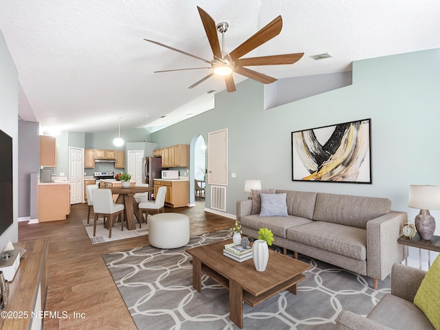 living room with ceiling fan, dark hardwood / wood-style flooring, and lofted ceiling