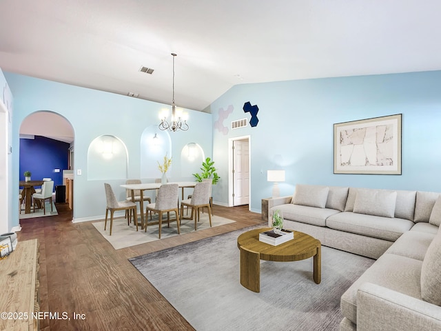 living room with hardwood / wood-style flooring, lofted ceiling, and an inviting chandelier