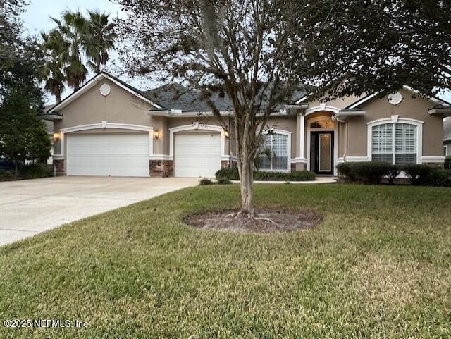 single story home featuring a garage and a front lawn