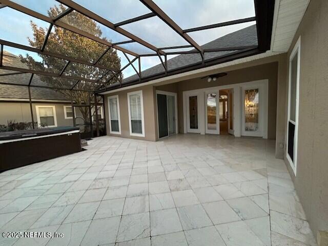 view of patio featuring a lanai and an outdoor hot tub