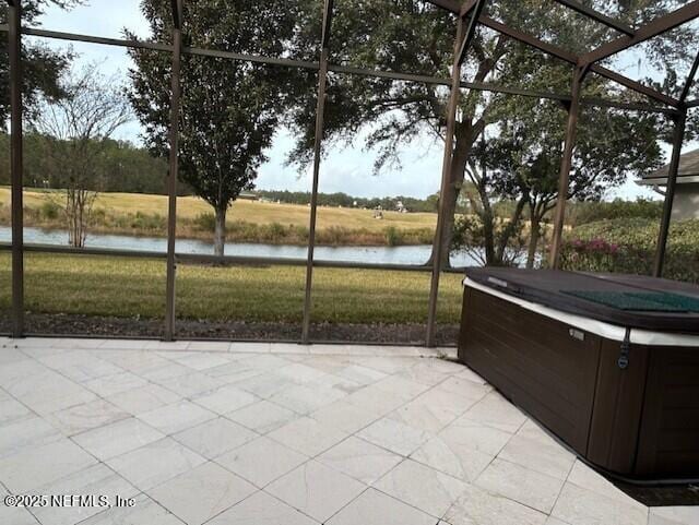 unfurnished sunroom featuring a jacuzzi and a water view